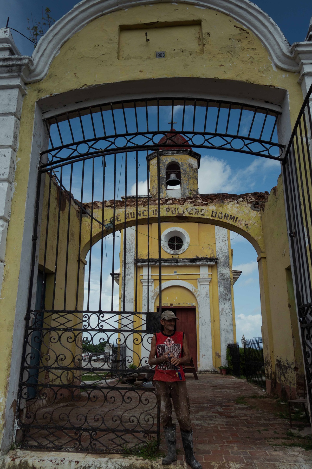 Osmany, sepulturero desde el año 2017, en la entrada principal del cementerio (Foto: Lucy Gmorell).