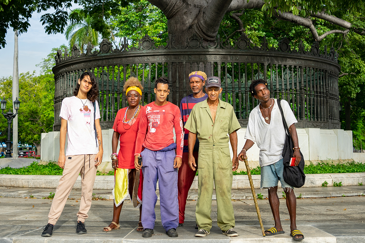 Posando bajo la ceiba (a los extremos), los asiduos al parque; (delante) dos integrantes de la brigada de mantenimiento y (detrás) un matrimonio religioso que consulta en el lugar (Foto: Alina Sardiñas).