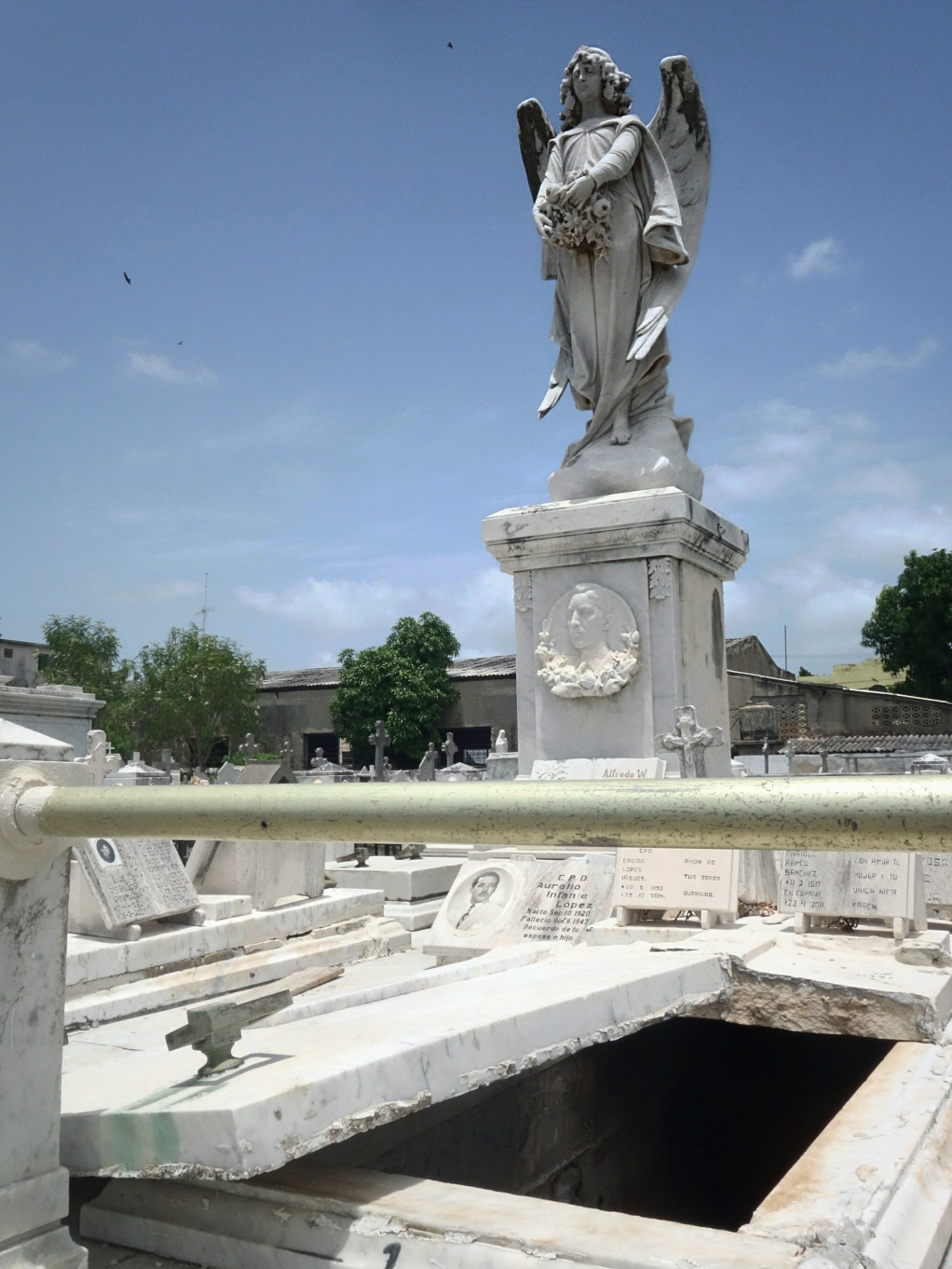 Panteón construido en mármol, con relevante estatua religiosa. Bóveda abierta, rota y vacía (Foto: Lucy Gmorell).