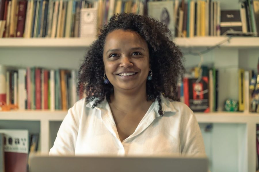 Retrato de Yanelis Núñez Leyva, activista cubana y miembro del Movimiento San Isidro, frente a un estante de libros. Su historia destaca la lucha por la libertad y la esperanza desde el exilio.