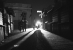 Calle oscura en Cuba, iluminada únicamente por la luz de una motocicleta en medio de un apagón.