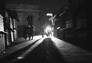 Calle oscura en Cuba, iluminada únicamente por la luz de una motocicleta en medio de un apagón.