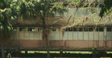 Vista del edificio principal de Ceiba 1 con ventanas metálicas y el nombre de la institución en la pared.