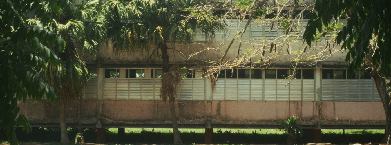 Vista del edificio principal de Ceiba 1 con ventanas metálicas y el nombre de la institución en la pared.