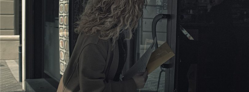 Mujer migrante cubana entregando su currículum en la puerta de un local en Barcelona, en busca de trabajo informal.