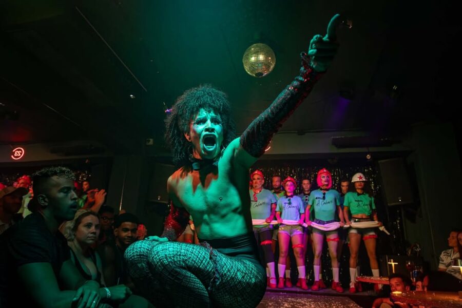 Miembros de la compañía de teatro El Portazo celebran juntos y sonríen en el escenario del Club 23, en La Habana.