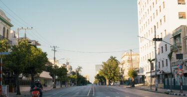 Avenida 23 vacía en horario pico atravesada por una pareja que viaja en moto eléctrica