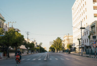 Avenida 23 vacía en horario pico atravesada por una pareja que viaja en moto eléctrica