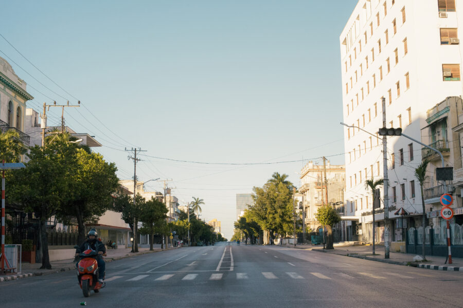 Avenida 23 vacía en horario pico atravesada por una pareja que viaja en moto eléctrica