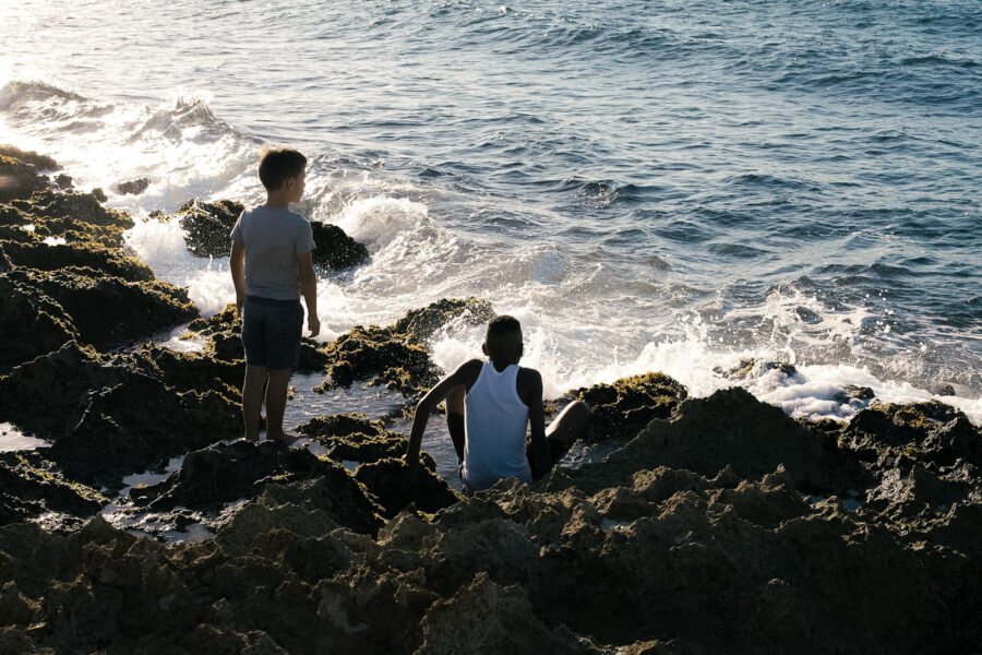 Niños juegan con las olas en las costas del municipio Playa durante apagón nacional del 21 de marzo de 2026. 