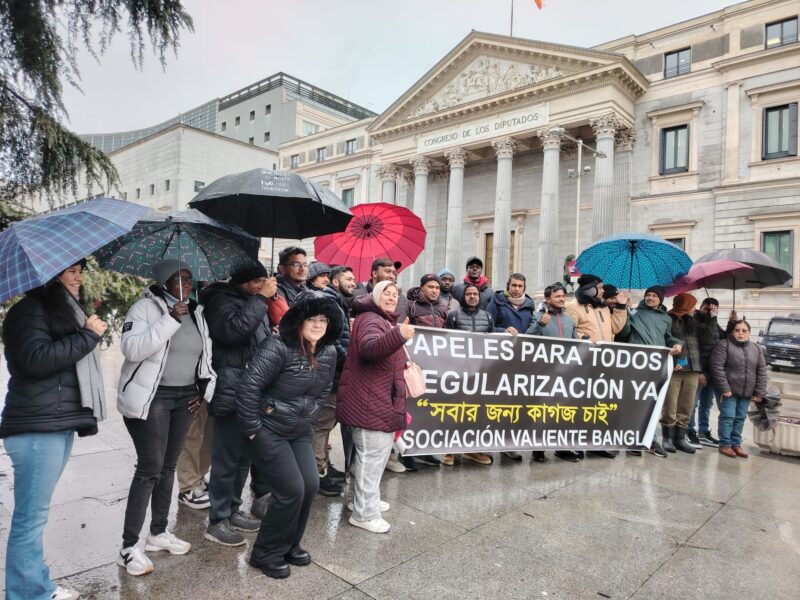a group of people holding umbrellas and a sign